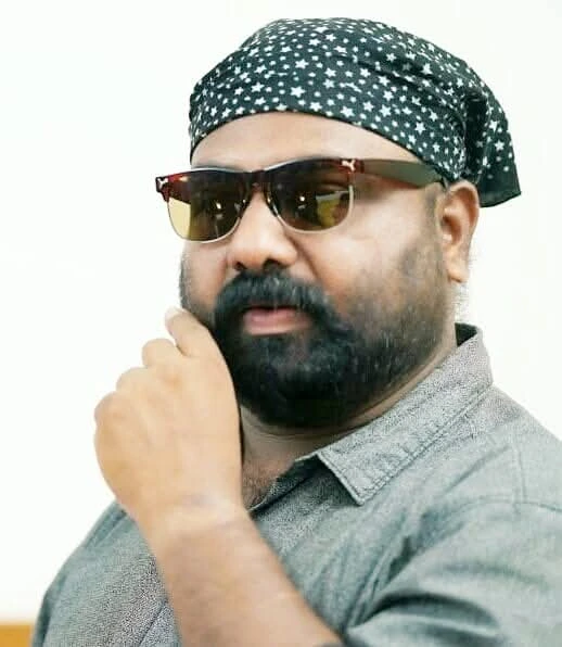 Vyasan Sajeev wearing sunglasses and a patterned head cloth